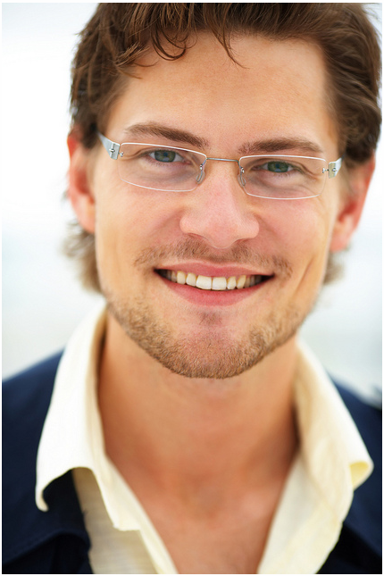 young man wearing glasses and smiling